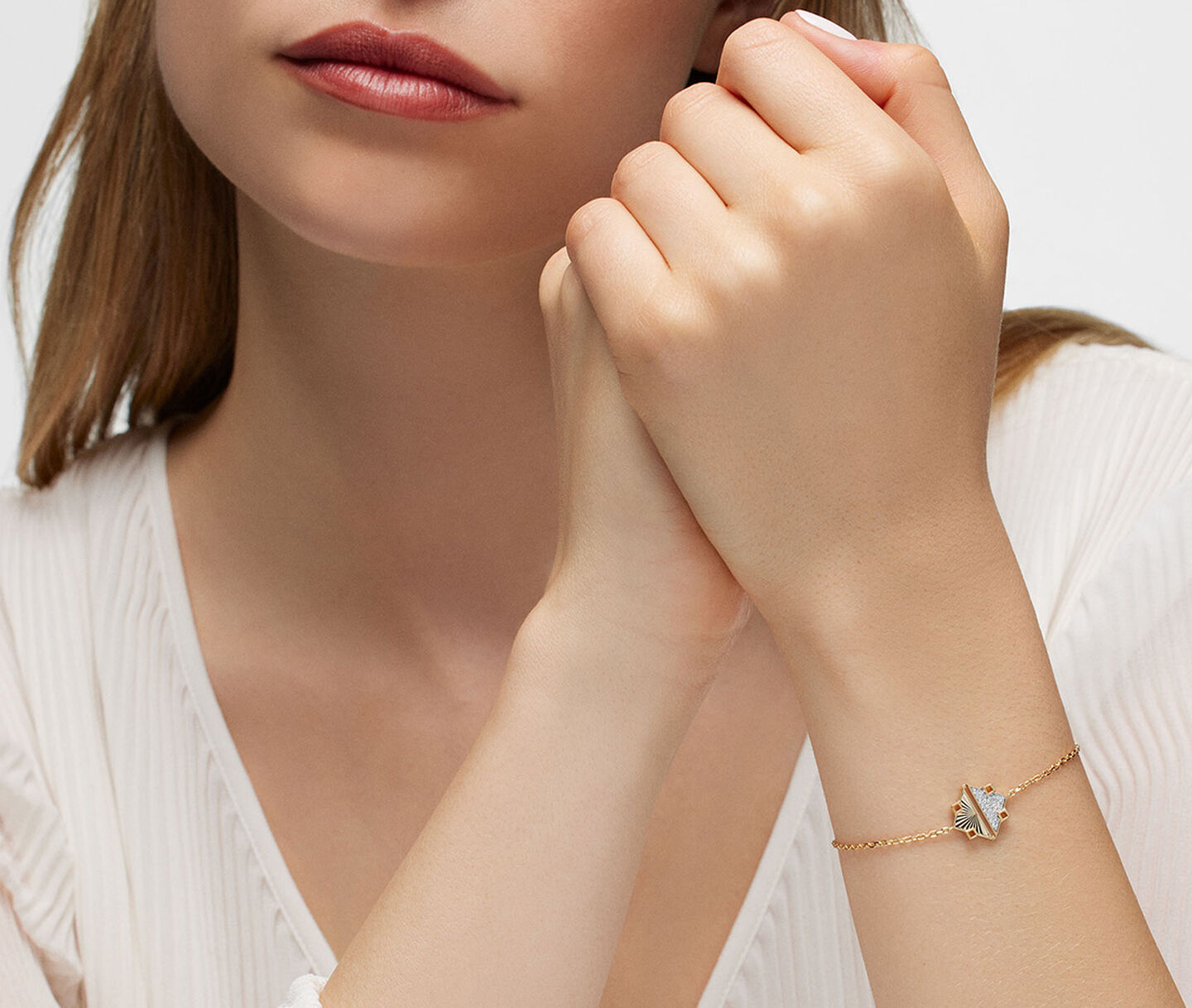 A woman wearing a Birks Muse yellow gold and diamond bracelet.